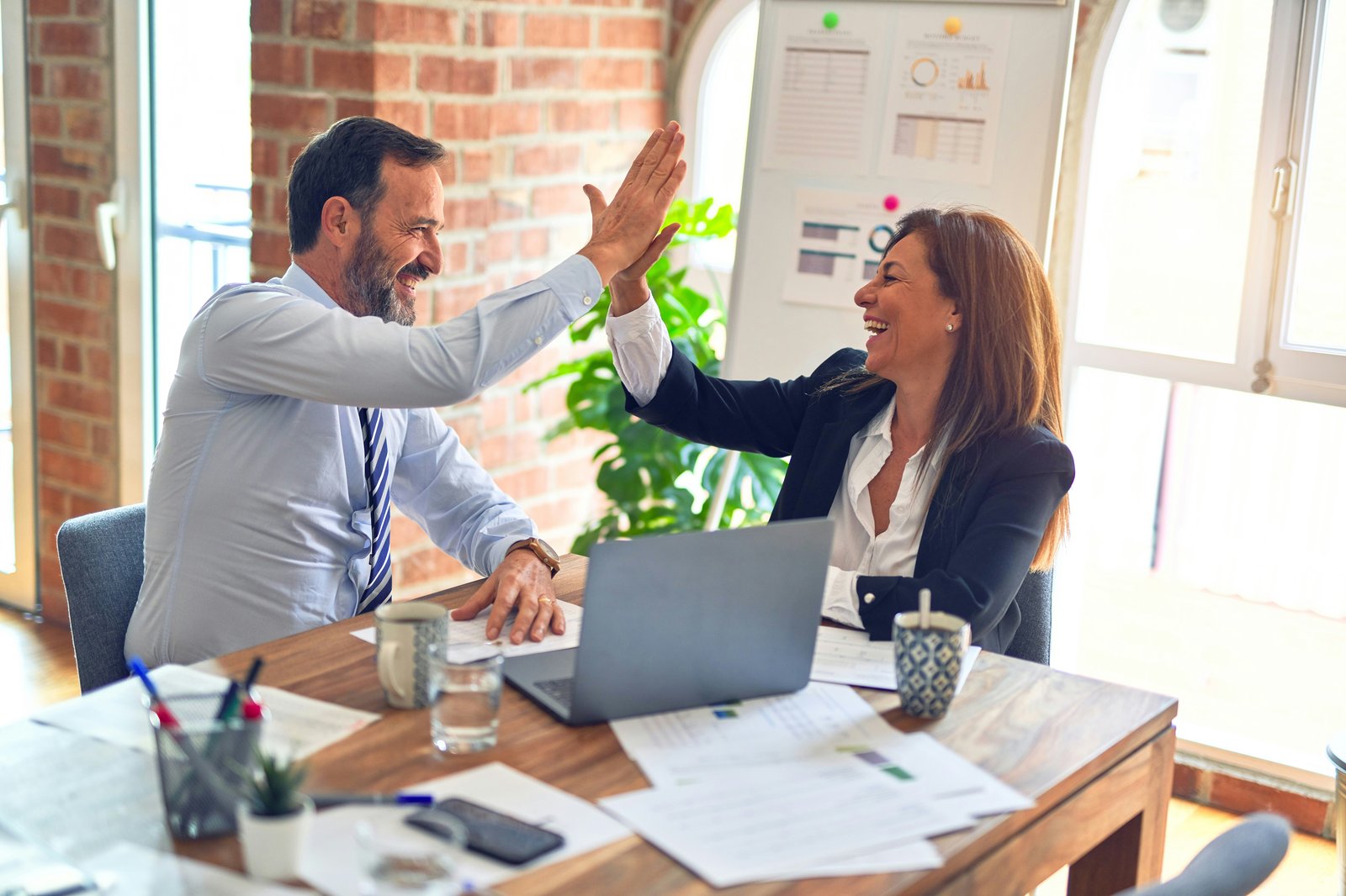 Two colleagues celebrating with a high five